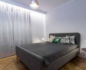 Minimalistyczna sypialnia z dużym, tapicerowanym łóżkiem