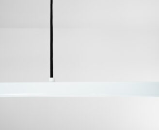 Lampa wisząca w kolorze białym i czarnym kablem w miejscu łączenia