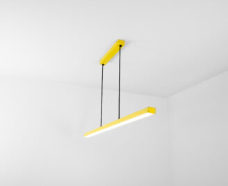 Lampa wisząca w kolorze żółtym i czarnym kablem widziana z boku