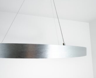 Lampa wisząca w kształcie ringu w srebrnym kolorze widziana z bliska